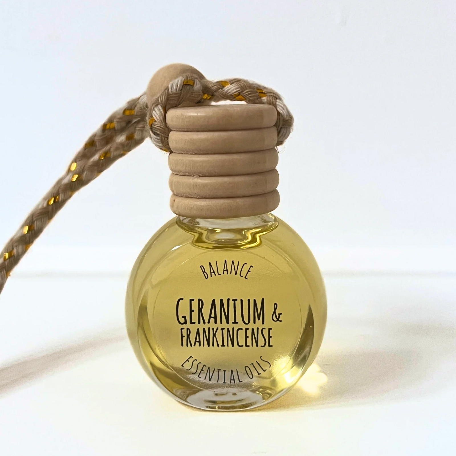 natural car diffuser, geranium and frankincense in a glass bottle with wooden cap feature on a white background